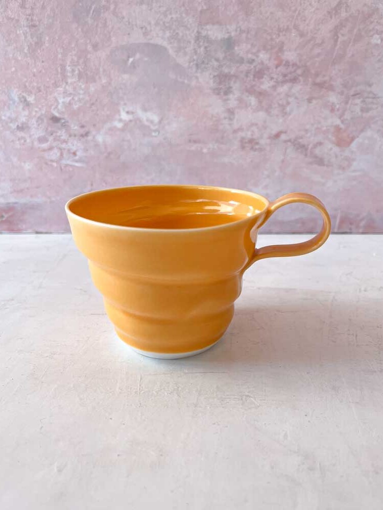 rikke mangelsen ceramics, porcelain cup in orange, coffee cup, cup, pastel-colored cup, coffee cup, tea cup, handmade ceramics, cups with handle, made in denmark, Danish design, remix by sofie, drill cover