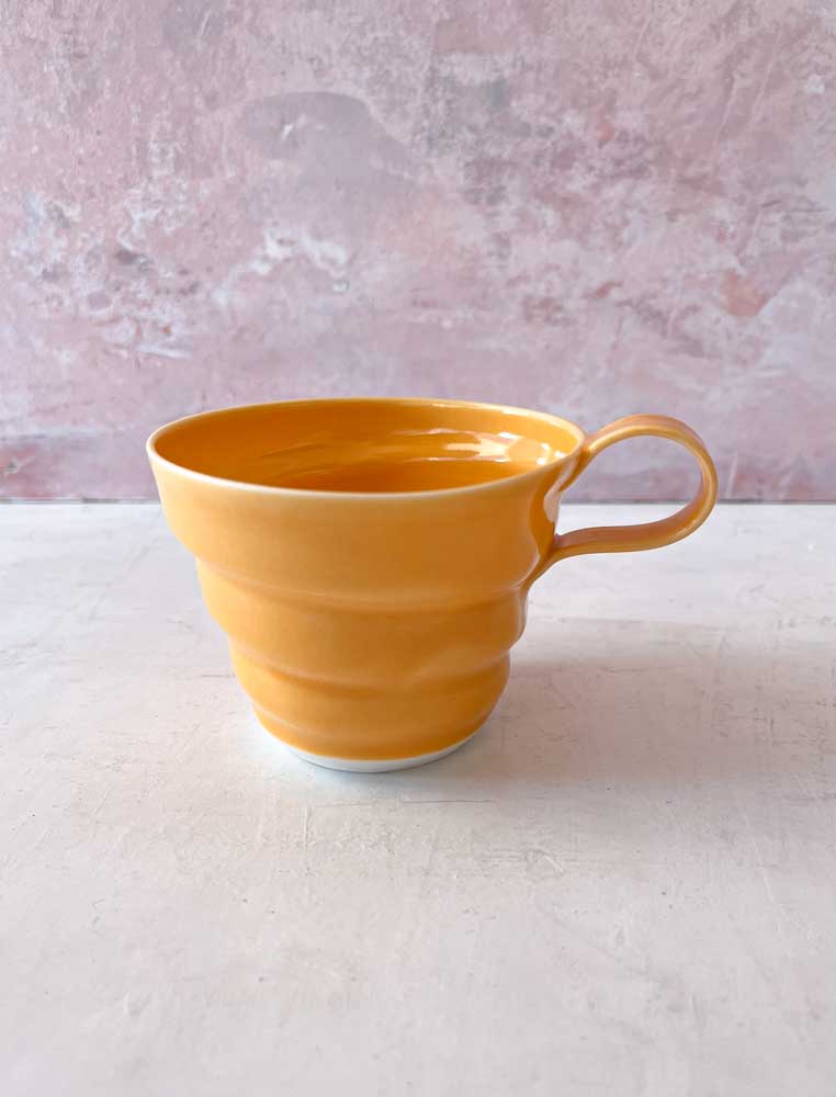rikke mangelsen ceramics, porcelain cup in orange, coffee cup, cup, pastel cup, coffee cup, tea cup, handmade ceramics, cups with handle, made in denmark, Danish design, remix by sofie, drill cover