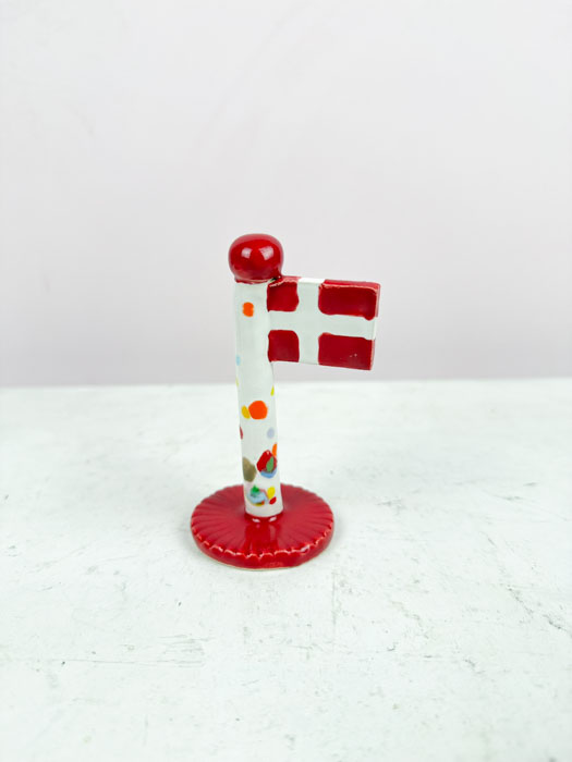 the clay play ceramic flag with red base